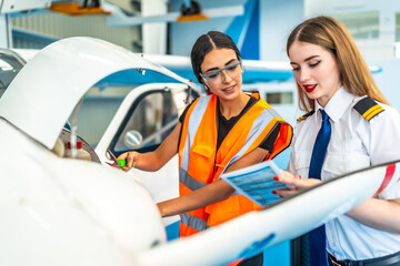 Female pilot and aircraft maintenance engineer performing pre flight check