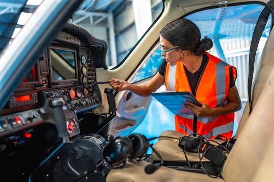 Aircraft maintenance engineer inspecting cockpit panel of small plane