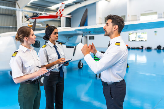 Flight instructor training pilots in hangar setting