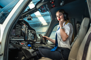 Female pilot sitting in cockpit of small airplane wearing headset