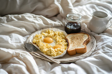 Tray with scrambled eggs, toast, tea, orange juice snd jam jars, on rumpled bed sheets ideal for soft lifestyle imagery.