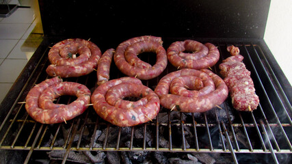 Grilled meat consisting of sausage and chops put to roast on the barbecue