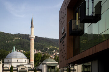 Modern Hotel Building Next to Historic Mosque with Minaret in Urban Setting