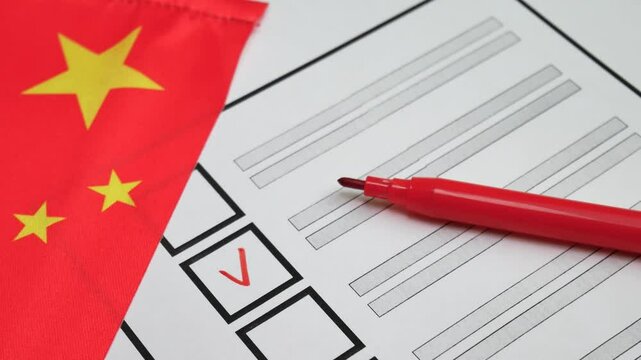 Voter uses red marker to mark candidate on paper ballot. Democratic elections in People Republic of China. Red flag with yellow stars in background. Electoral process, political decision making