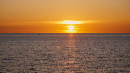 Breathtaking sunset over a calm ocean, creating a magical atmosphere with warm colors during twilight