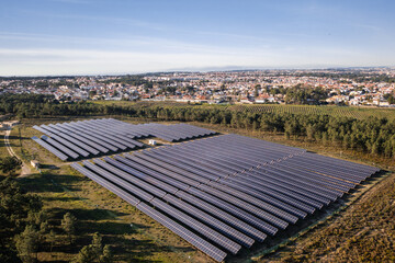 Aerial drone view of solar panels in fields, generating sustainable energy with a scenic townscape...