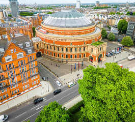 Aerial view of the Royal Albert Hall in London, surrounded by classic red-brick buildings, roads, and green trees