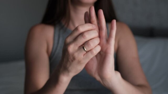 Close-up of a young woman with eczema on her hands. She scratches and shows dry, flaky, irritated skin. Ideal for medical or dermatology topics.
