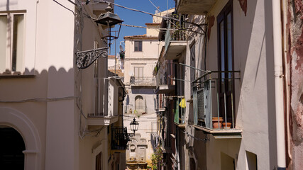 Traditional narrow street with balconies, clothes hanging and street lamps in Pizzo, Calabria, a charming town in Southern Italy
