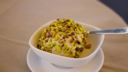 Pistachio tartufo ice cream served in a white bowl on a table in Pizzo, Calabria, Italy