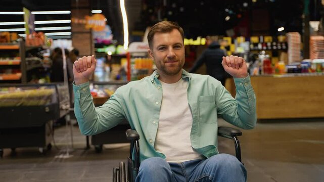 Happy customer in wheelchair man dancing in supermarket