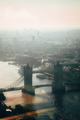Sunset view over London with Tower Bridge and the Thames River seen through glass reflections from...