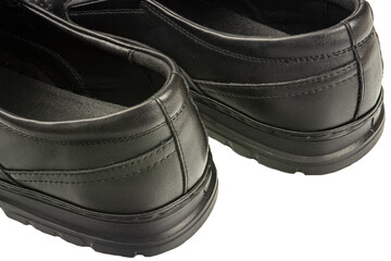 close-up details of black leather classic summer shoes with perforated trim.