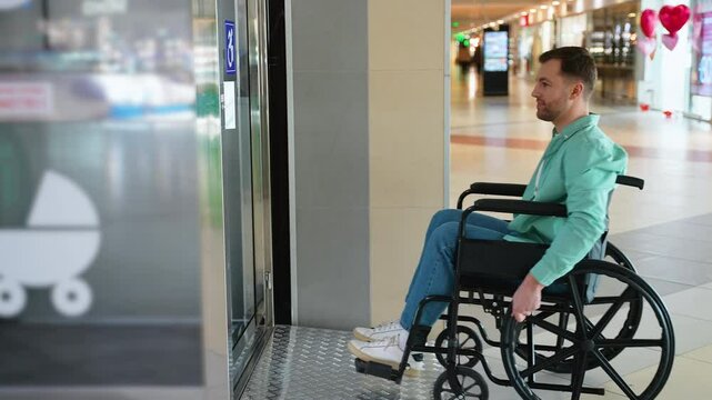 Man in wheelchair entering elevator in shopping mall