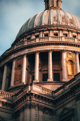 Close-up of St. Paul&rsquo;s Cathedral dome in London, captured in warm evening light with dramatic shadows.