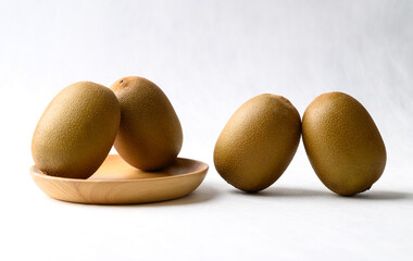 Fresh kiwi fruit with wooden plate on white background, Healthy fruit