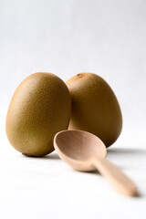 Fresh kiwi fruit with wooden spoon on white background, Healthy eating