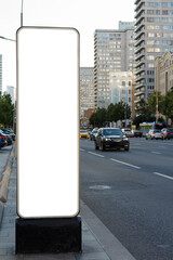 Long billboard in the city near the road. Tall buildings, traffic. Mock-up.