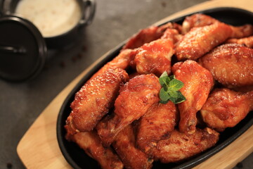 Korean-style fried chicken wings and drumsticks served in a skillet. Crispy texture with sweet and spicy glaze. A popular K-Food dish enjoyed at home and in restaurants.

