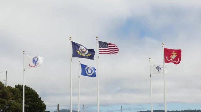 American and armed forces flags in wind