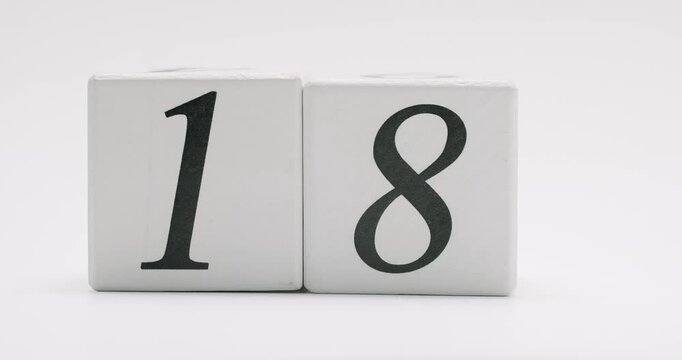 Wooden number blocks displaying the number eighteen, symbolizing the 18th day of the month, on a white background. Wooden Number Blocks Showing The Date Eighteenth On A White Background