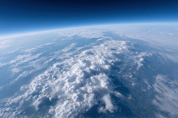 Naklejka premium The Earths curved horizon captured from a high altitude is seen with a dense cloud cover and a dark blue sky above