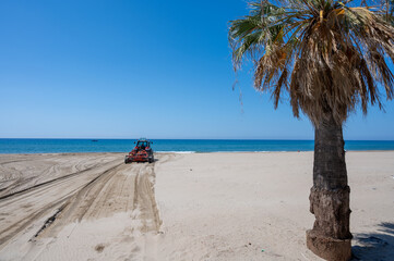 Beach maintenance work before the season, tractor cleans seaweed and loosens sand, paid beaches in...