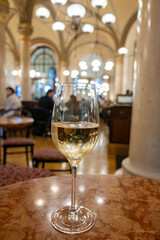 Lifestyle of beautiful Vienna, glass of cold white dry Austrian wine served in old Viennese-style cafe in Vienna, Austria