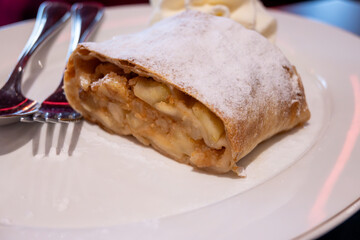 Austrian desserts, piece of apple strudel with whipped cream served in old traditional bakery cafe...