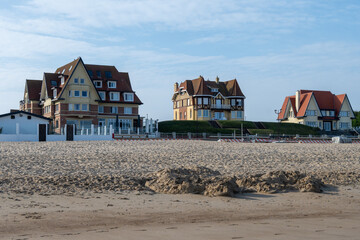 White sandy beach in cosy seaside holiday village on North Sea, built in belle epoque style in Flanders, De Haan or Le Coq sur Mer, Belgium