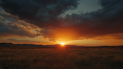 Obraz premium Radiant Sunset Over Golden Prairie Landscape with Dramatic Cloud Formations