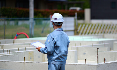 住宅建築の基礎を点検する工事監督