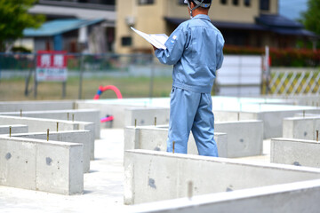 住宅建築の基礎を点検する工事監督