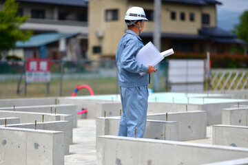 住宅建築の基礎を点検する工事監督
