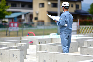 住宅建築の基礎を点検する工事監督