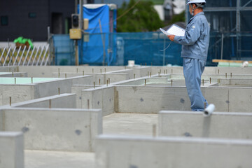 住宅建築の基礎を点検する工事監督