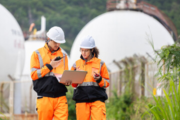 Engineers Collaborating at Industrial Site with Storage Tanks, Team of Engineers Conducting...