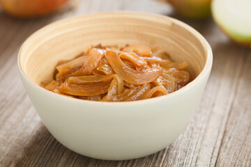 Caramelized fried yellow onion slices in bowl with onion in the back (Selective Focus, Focus  on the onion slices in the front)