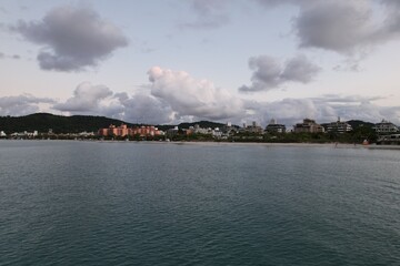 Calm seaside view from the water with buildings in the background at dusk