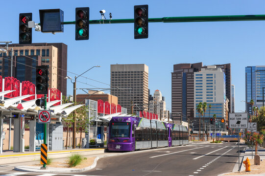 Valley Metro B Line light rail train at Central Avenue station in downtown Phoenix, operating on new extension with updated platform, signal, and urban infrastructure.