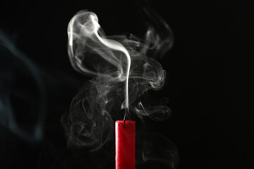 Beautifully shaped smoke rising from an extinguished candle wick.