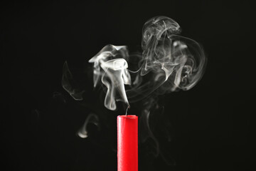 Beautifully shaped smoke rising from an extinguished candle wick.