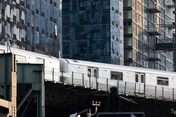 Subway train passing through modern skyscraper apartment buildings