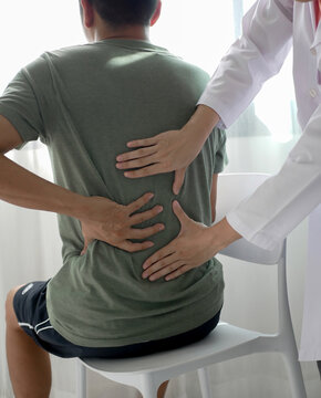 Asian male patient receives physical therapy with a physical therapist specializing in pain management in a hospital