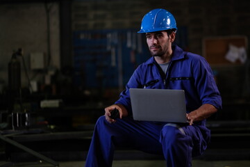 Fototapeta premium Portrait of foreman, engineer or architect with safety helmet holding laptop and blueprints for inspection details on factory industry material.