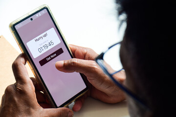 Man using phone displaying real-time notification about sales ending in a short time frame. FOMO Marketing strategy, online shopping concept.