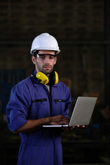 Fototapeta premium Portrait of foreman, engineer or architect with safety helmet holding laptop and blueprints for inspection details on factory industry material.