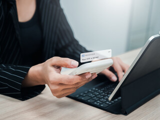 Two steps authentication, validate password, cybersecurity technology concept. OTP password code, sms alert showing on mobile smart phone in businesswoman hand while login with laptop computer.