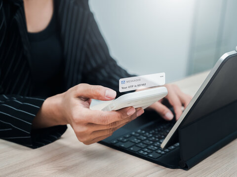 Two steps authentication, validate password, cybersecurity technology concept. OTP password code, sms alert showing on mobile smart phone in businesswoman hand while login with laptop computer.