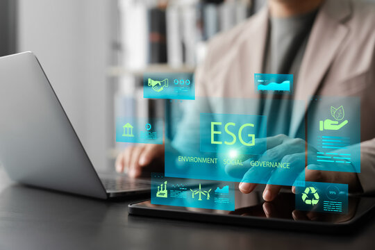 Businessman using ESG Environmental, Social, Governance digital dashboard on tablet for sustainable investment analysis, corporate responsibility, and ethical business practices.